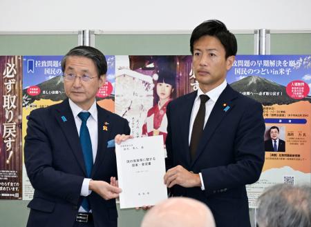 鳥取県の平井伸治知事（左）から拉致問題の完全解決を求める要望書を受け取る鈴木隼人内閣府副大臣＝２４日午後、鳥取県米子市
