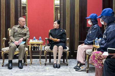 少女の関係者と面会するタイ警察のタッチャイ副長官（左端）＝２４日、バンコク（共同）