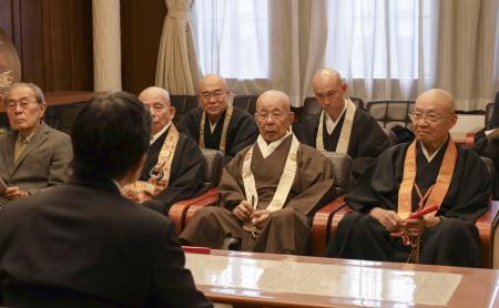 京都市の松井孝治市長（手前）と面会する京都仏教会の宮城泰年常務理事（右から３人目）ら＝２５日午後、京都市役所