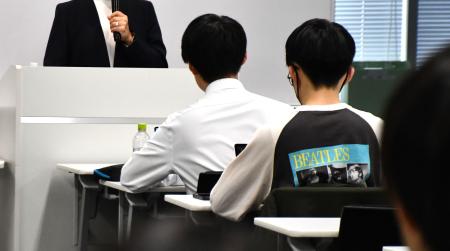 中央大キャンパスで学生に講演する岩瀬裕見子さん（壇上）＝２５日午前、東京都新宿区