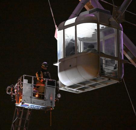 観覧車に閉じ込められた乗客を救助する消防隊員=26日午前2時34分、大阪府吹田市