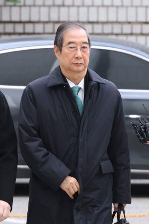 ２６日、公判のためソウル中央地裁に入る韓悳洙前首相（聯合＝共同）