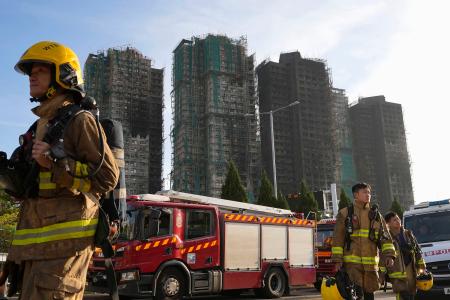 消火活動が続く火災現場の高層住宅＝２８日、香港北部・新界地区大埔（共同）