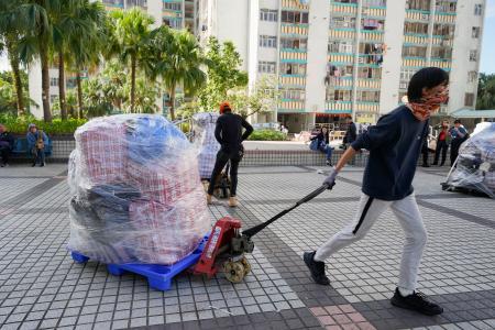地元警察の求めに応じ、被災者のために用意した衣類などの物資を移動するボランティア＝２９日、香港北部・新界地区大埔（共同）