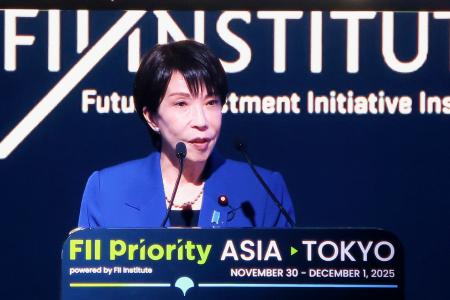 会場内のモニターに映し出された高市首相＝１日午前、東京都港区