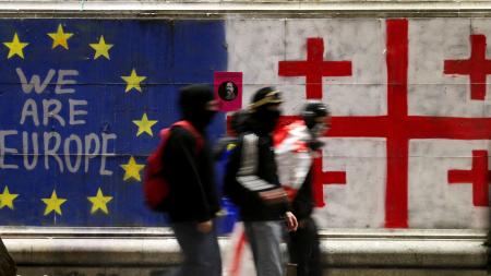 ２０２４年１２月に行われた、ＥＵ加盟交渉凍結を宣言した政府への抗議デモで、ＥＵ旗とジョージアの国旗の色に塗られた壁＝トビリシ（ロイター＝共同）