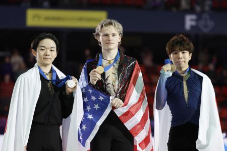 ２０２４年１２月、フィギュアスケート、ＧＰファイナルの男子表彰式でメダルを掲げる（左から）２位の鍵山優真、優勝のイリア・マリニン、３位の佐藤駿＝グルノーブル（共同）