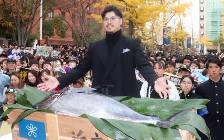 母校の近大に凱旋（がいせん）し、贈呈された「近大マグロ」を前にポーズを決める阪神・佐藤輝＝２日、大阪府東大阪市