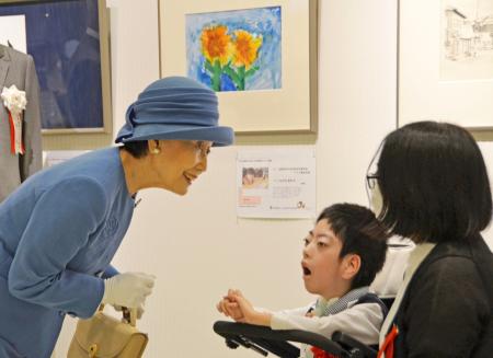 日本肢体不自由児協会が主催する美術展と写真展を鑑賞された常陸宮妃華子さま。中央はヒマワリの絵を描いた永田悠人さん＝３日午前、東京都豊島区