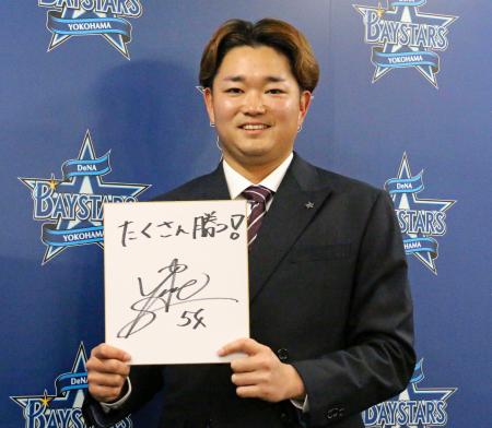 来期の抱負を書いた色紙を手にポーズをとるＤｅＮＡの石田裕＝４日、横浜市の球団事務所