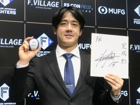 　契約交渉を終え、色紙を手にポーズをとる日本ハム・北山＝４日、エスコンフィールド