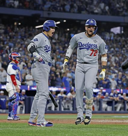 　ワールドシリーズ第７戦、ブルージェイズ戦の９回、同点ソロを放ったロハス（右）を迎えるドジャース・大谷＝１１月、トロント