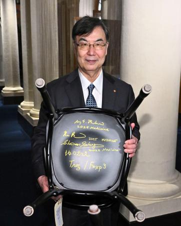 ストックホルムのノーベル博物館を訪問し、椅子の裏に書いたサインを披露する坂口志文・大阪大特任教授=6日(ロイター=共同)