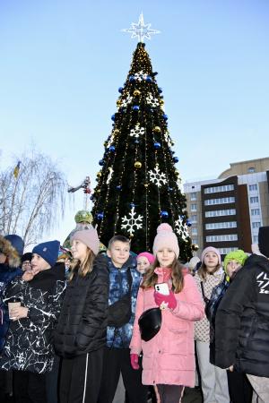 6日、ウクライナ・ボロディアンカで点灯したクリスマスツリーと集まった市民ら(共同)