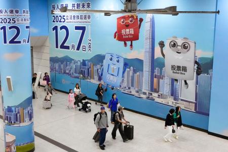 駅構内の壁一面に張られた立法会選挙の投票を呼びかける広告=6日、香港(共同)