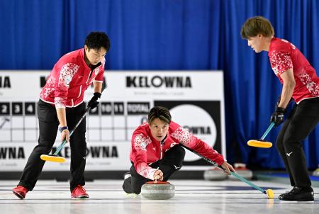 男子1次L 米国戦の第2エンド、ショットを放つ山口。左は山本、右は小泉=ケロウナ(共同)