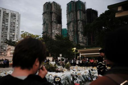 火災が起きた高層住宅群近くに手向けられた花束=7日、香港(共同)