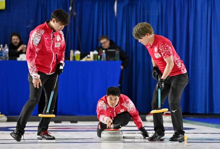 　男子１次Ｌ　ポーランド戦の第３エンド、ショットを放つ臼井。左は柳沢、右は小泉＝ケロウナ（共同）