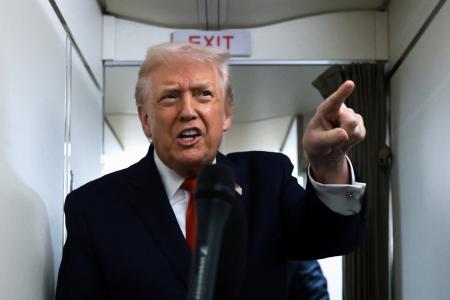 大統領専用機「エアフォースワン」の機内で報道陣の取材に応えるトランプ大統領＝９日（ロイター＝共同）