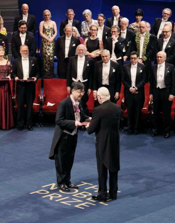 ノーベル賞授賞式で、スウェーデンのカール16世グスタフ国王(手前右)から生理学・医学賞のメダルと賞状を授与される坂口志文・大阪大特任教授(同左)=10日、ストックホルムのコンサートホール(代表撮影・共同)