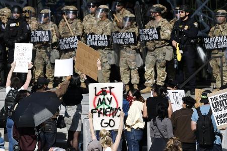 ６月、米ロサンゼルスで州兵や警察と対峙する抗議活動の参加者（ゲッティ＝共同）