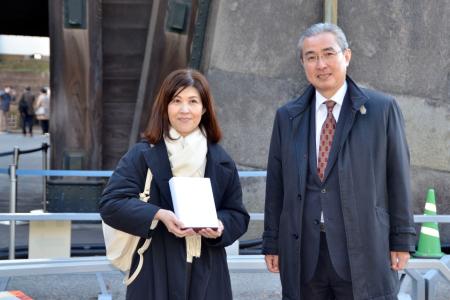 皇居・東御苑の４千万人目の入園者として宮内庁の古賀浩史管理部長（右）から記念品を受け取った山田裕美子さん＝１１日午後、東京都千代田区