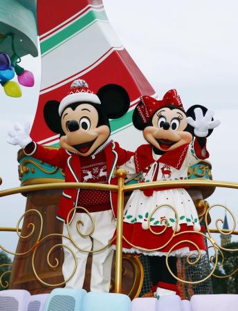 東京ディズニーランドのクリスマスを祝うパレードで手を振るミッキーマウスとミニーマウス=2015年11月、千葉県浦安市
