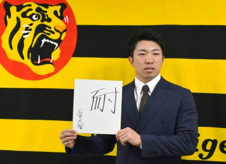 契約更改し、今季を表す漢字「耐」を掲げる阪神・石井＝１２日、兵庫県西宮市