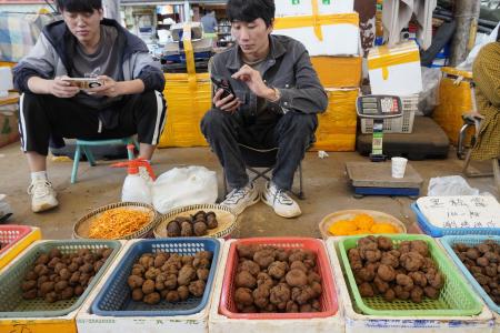 中国雲南省昆明市の市場で黒トリュフを売る人たち＝１０月（共同）