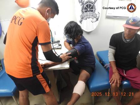 南シナ海で負傷し、手当てを受けるフィリピン漁船の漁師＝１３日（フィリピン沿岸警備隊提供・ＡＰ＝共同）