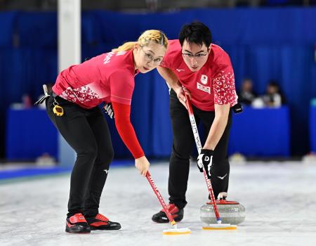 混合ダブルス１次Ｌ　韓国戦の第３エンド、スイープする小穴桃里（左）、青木豪＝ケロウナ（共同）