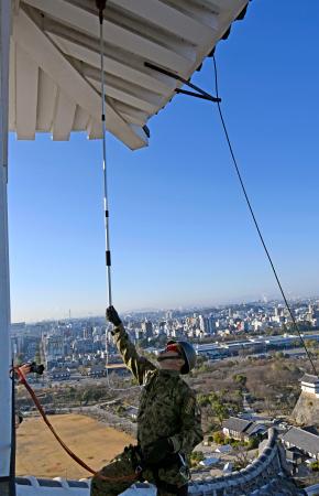 姫路城で「すす払い」を行う陸上自衛隊員＝１６日午前、兵庫県姫路市