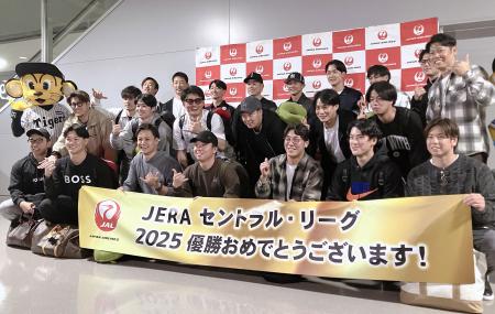 優勝旅行の出発前に記念撮影する阪神の選手ら＝１６日、関西空港