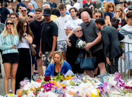 悲しみに暮れる犠牲者の親族ら＝１６日、オーストラリア・シドニー（ロイター＝共同）