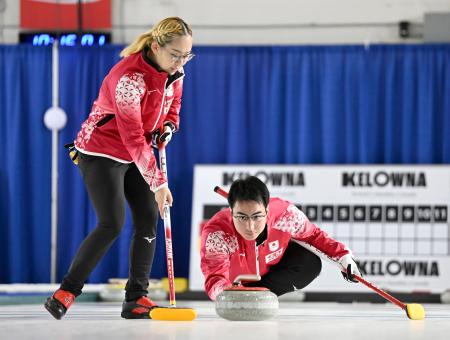 混合ダブルス１次Ｌ　フィンランド戦の第２エンド、ショットを放つ青木豪。左は小穴桃里＝ケロウナ（共同）