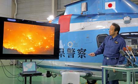 火災現場を上空から撮影した映像について説明する大分県警航空隊の宮副一成副隊長＝１８日午前、大分県国東市