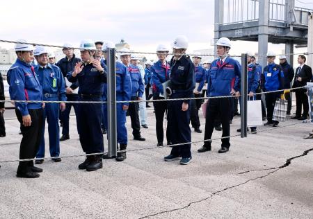 八戸港を視察し、路面のひび割れなどを確認する金子国交相（左端）＝２０日午後、青森県八戸市