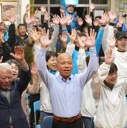 沖縄県南城市長選で初当選を決め、万歳する大城憲幸氏（手前中央）＝２１日夜、南城市