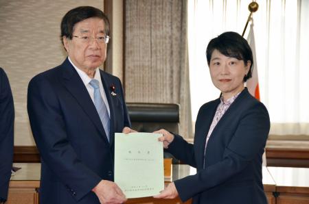 出入国在留管理政策懇談会の野口貴公美座長（右）から報告書を受け取る平口法相＝２２日午前、法務省