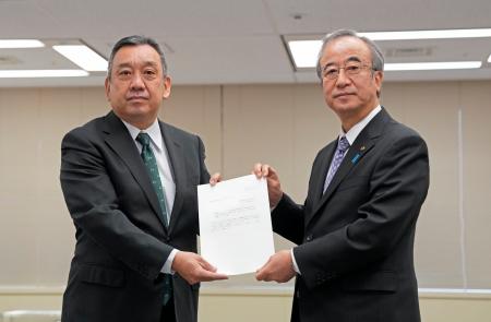 原子力規制庁の金子修一長官（左）に確認を依頼する文書を手渡す新潟県の花角英世知事＝２３日午前、東京都港区