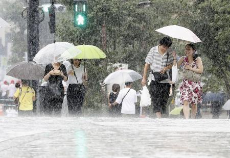 台風が接近し土砂降りの雨の中を歩く人たち＝２０１９年９月、東京都品川区