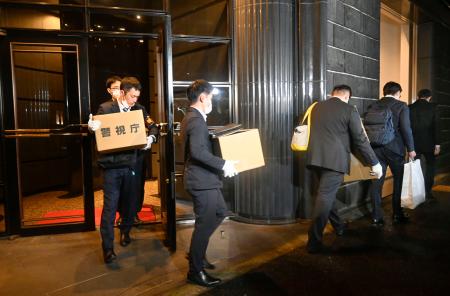 運営会社の関係先を家宅捜索し、段ボールを運び出す警視庁の捜査員ら＝２５日午後５時２６分、東京都港区