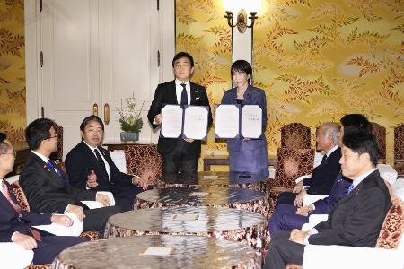 １８日、国会内で会談し「年収の壁」引き上げを巡る合意書を手にする高市早苗首相（奥右）と国民民主党の玉木雄一郎代表（同左）