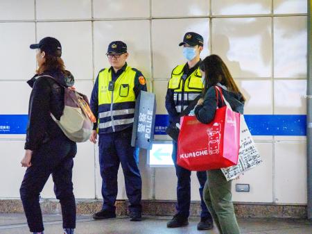 爆破予告を受けて、地下鉄の台北駅周辺を警戒する警察官＝２２日、台北市（共同）