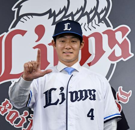 日本ハムから西武に移籍し、記者会見でポーズをとる石井＝２６日、埼玉県所沢市