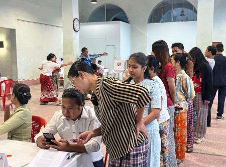 ２８日、ミャンマー最大都市ヤンゴンの投票所に並ぶ有権者ら（共同）