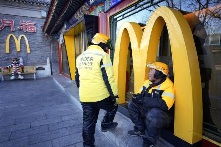 北京市内のファストフード店で待機する配達員＝２０２５年１２月（共同）