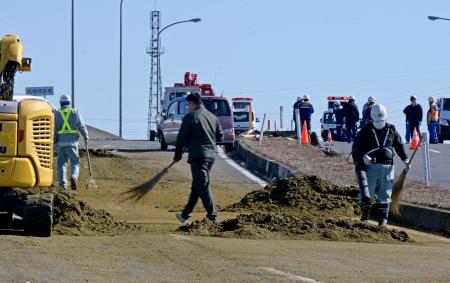 車十数台が絡む事故現場付近で散乱した茶葉の除去作業＝４日午前１１時３０分、栃木県佐野市