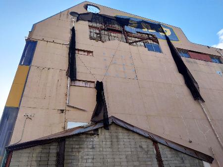 地震の影響で外壁が崩れたとみられる建物＝６日午前１１時３０分ごろ、松江市