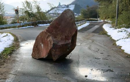 地震の影響で道路に落下した石=7日午前8時57分、鳥取県伯耆町